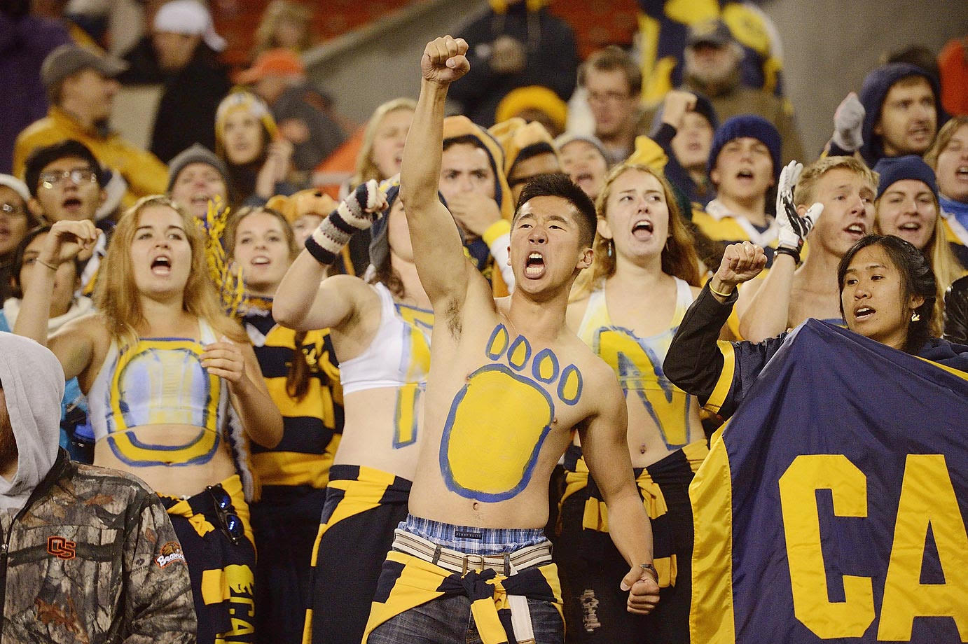 Cal sports fans cheering on team, dressed (or painted) in blue and gold.