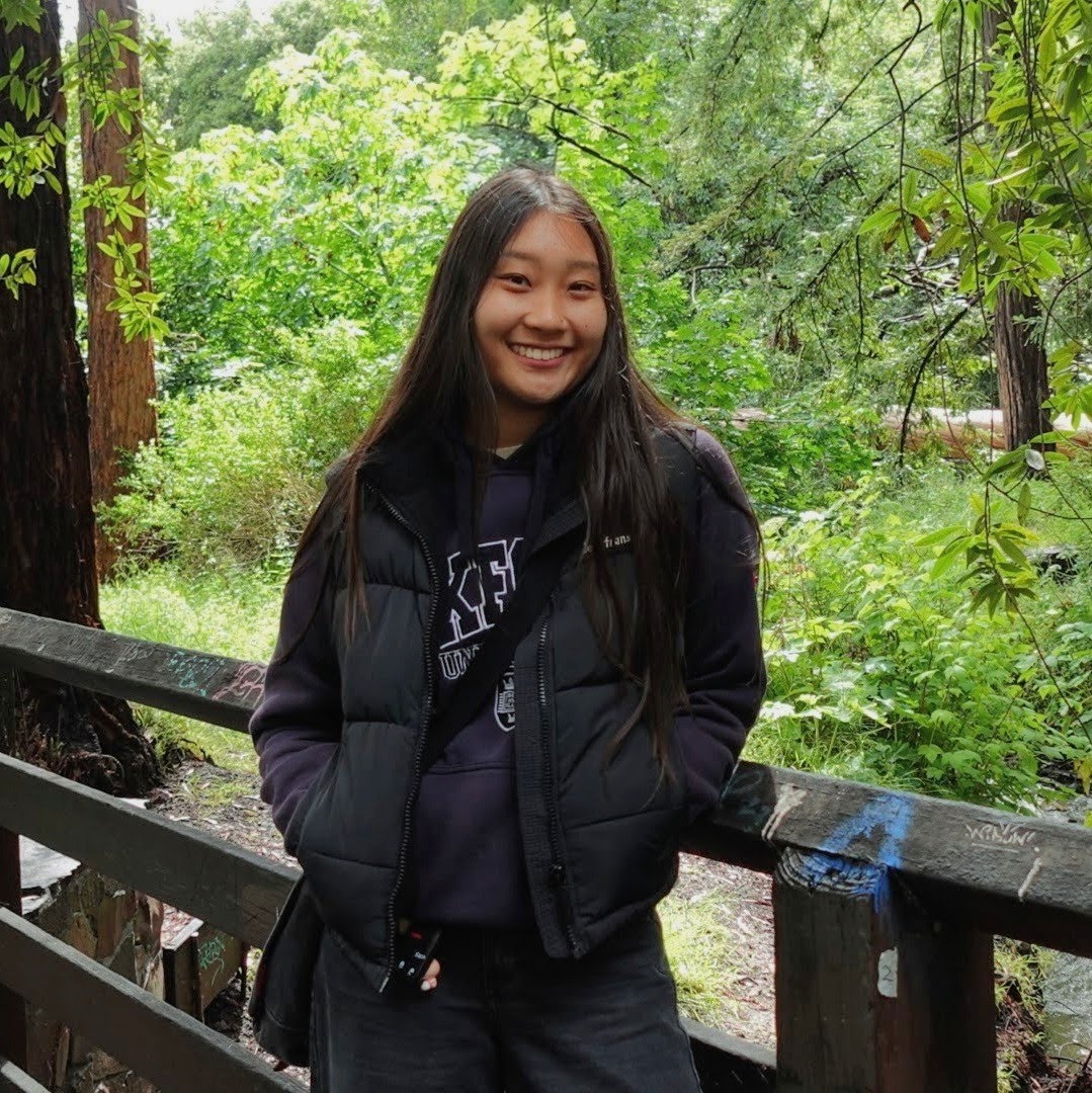 Woman standing in front of trees.